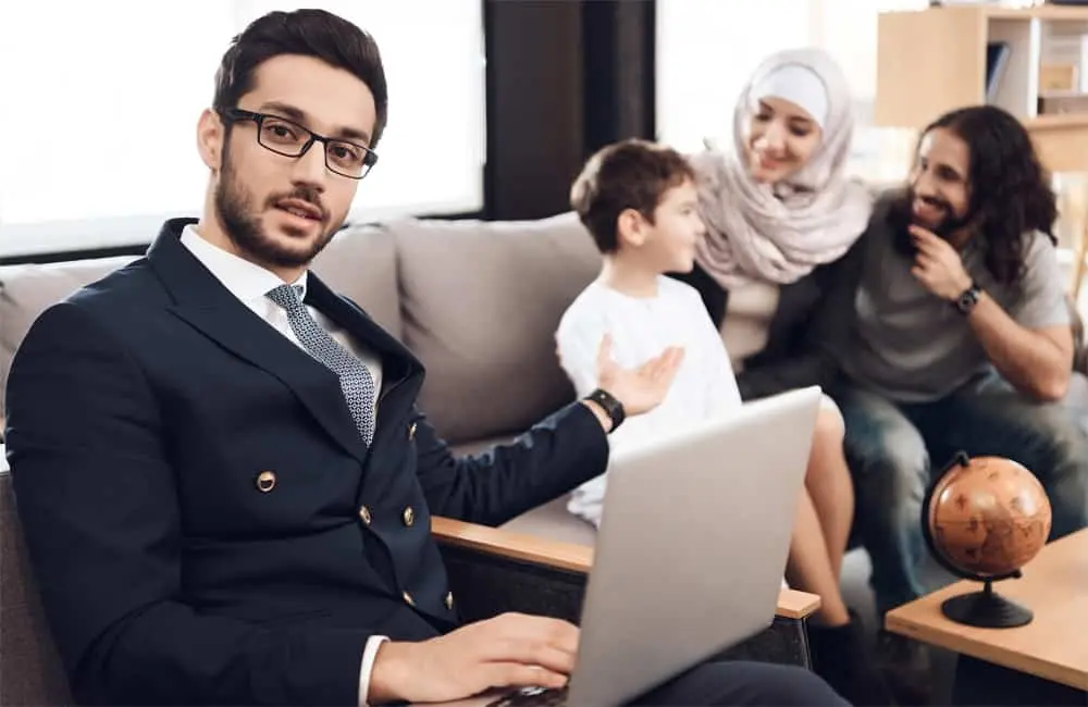 Mężczyzna, psycholog z laptopem, obok siedzi kobieta i dwójka dzieci